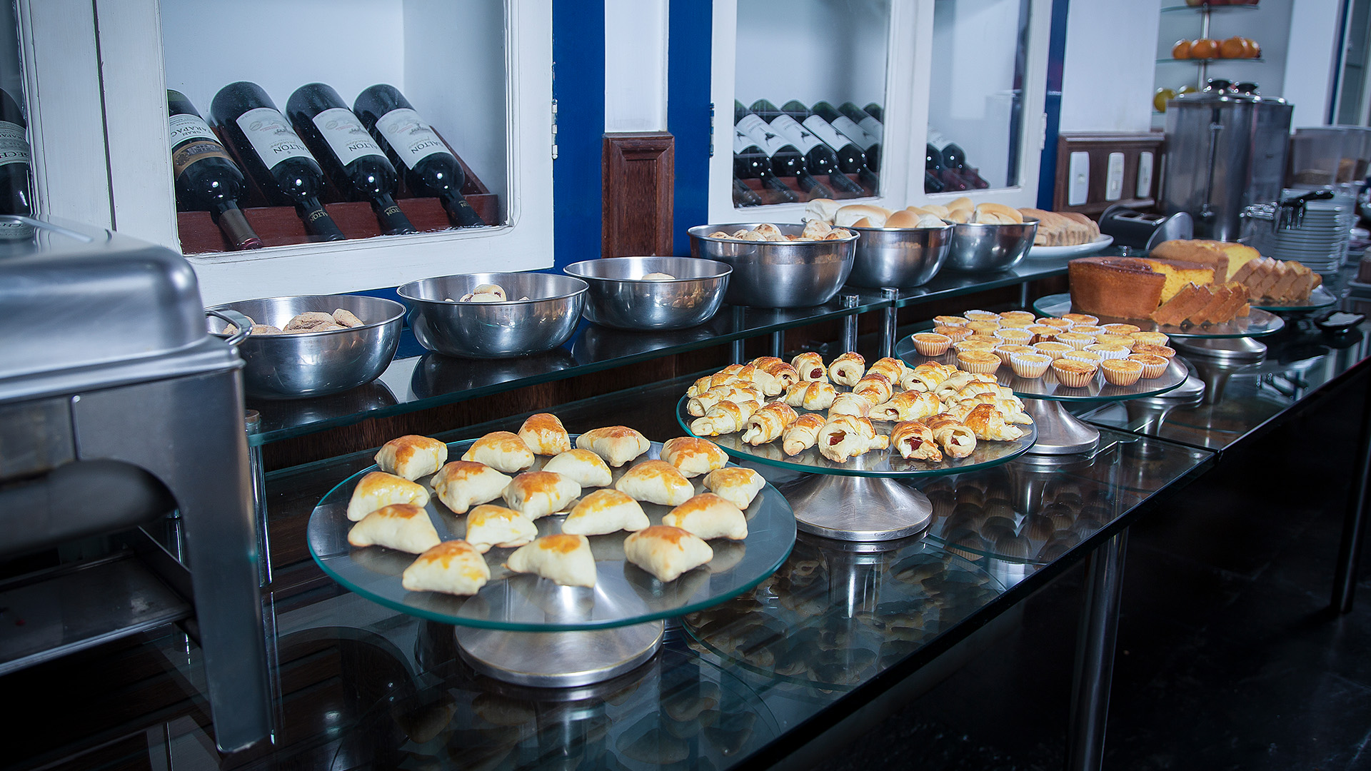 Mesa posta para o café da manhã com sucos, frutas e pães