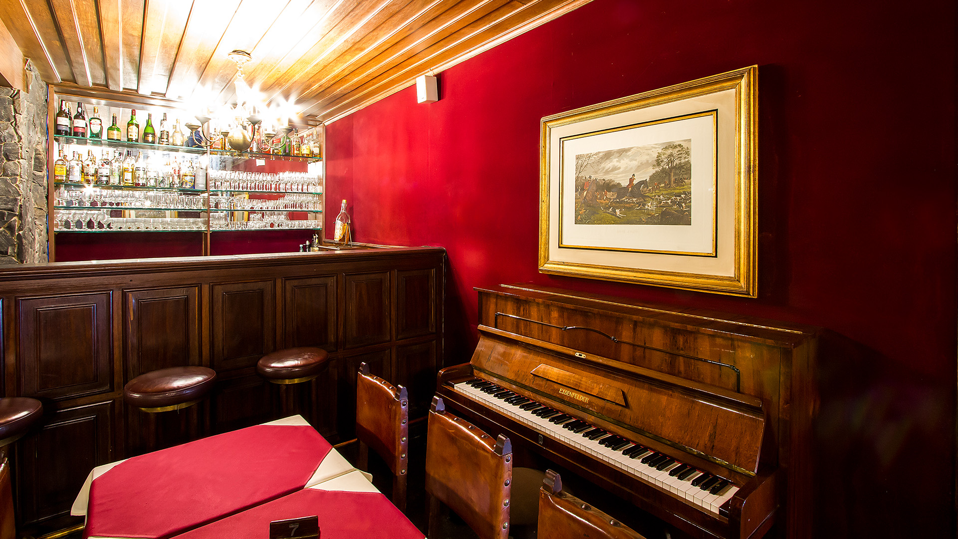 Scotch Bar com paredes vermelhas e piano